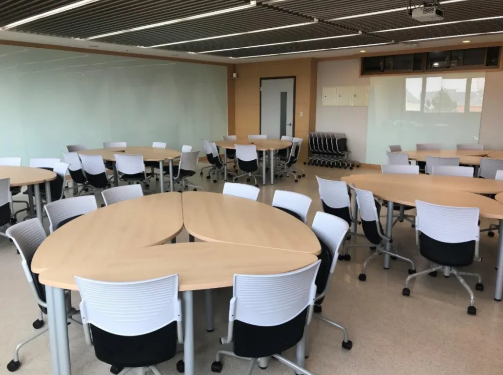 This innovative classroom features glass-paneled walls and modular furniture configurations, enabling flexible teaching arrangements that foster collaborative and adaptable learning.